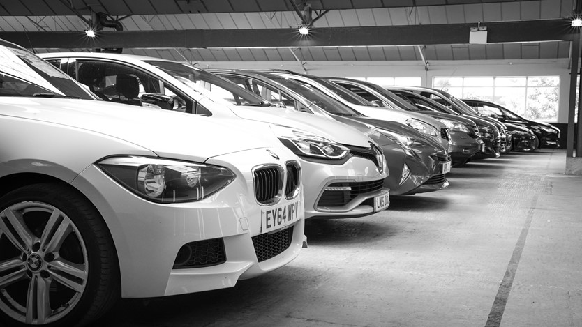 black and white photograph of cars in a parking lot